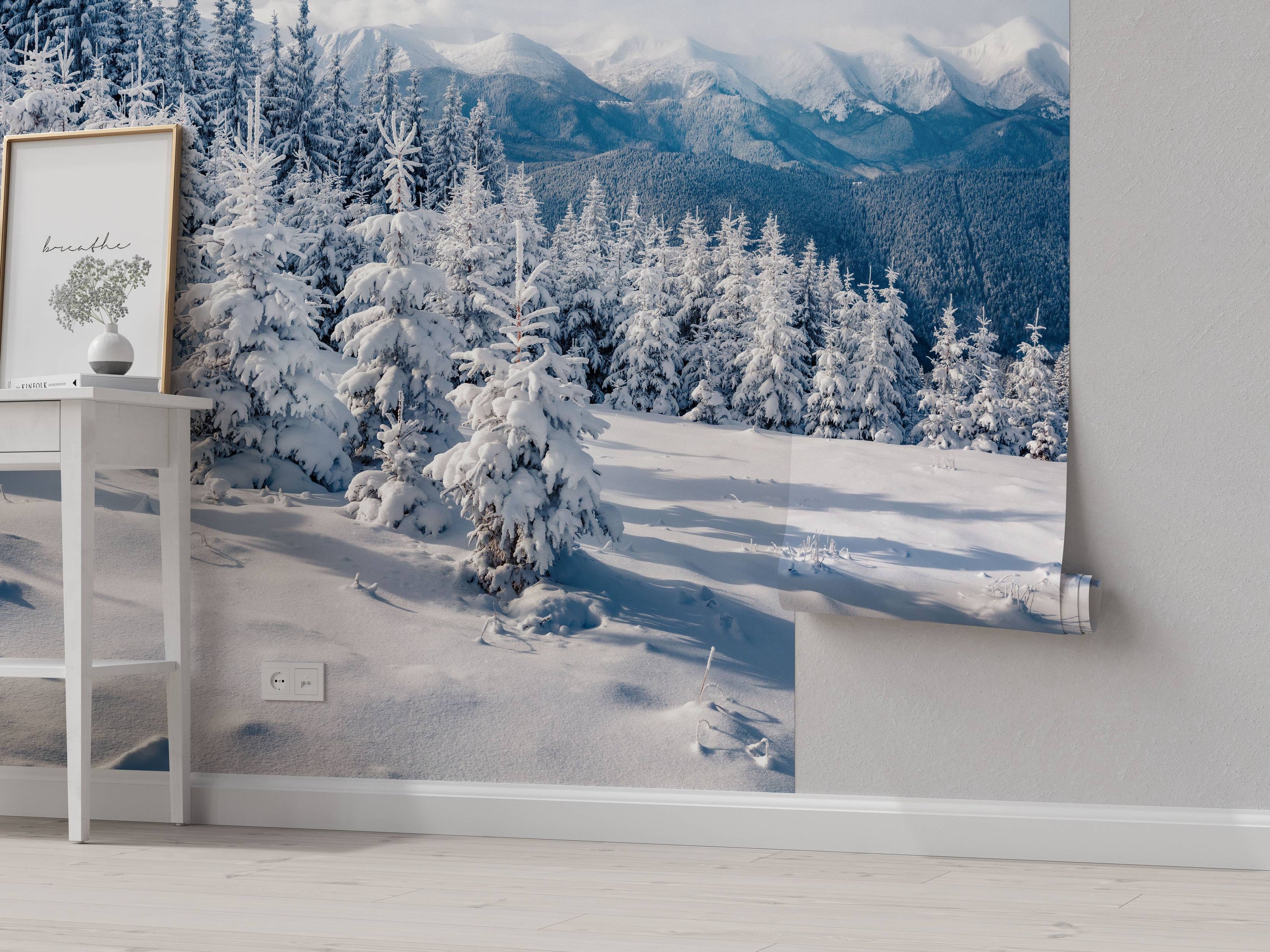 A photorealistic mural of a snowy mountain landscape with pine trees in the foreground and distant peaks in the background.