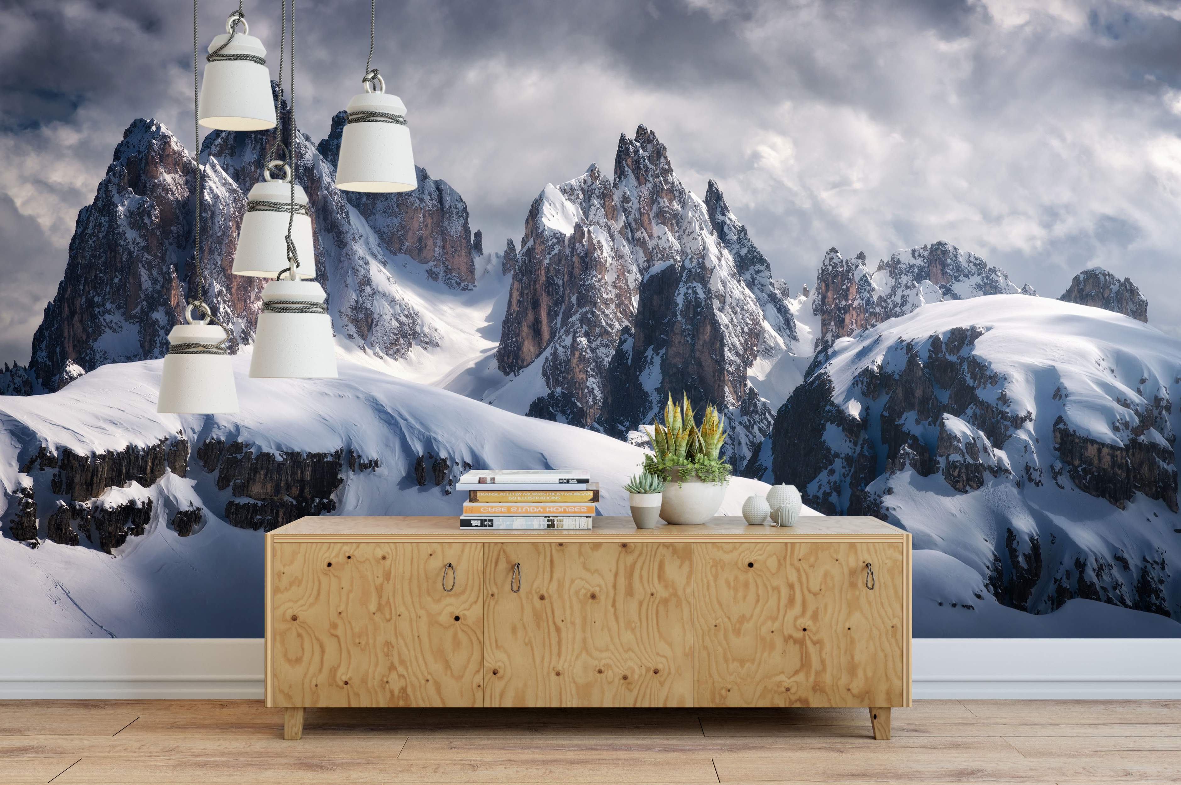 Photorealistic mural depicting jagged, snow-covered mountain peaks beneath a dramatic, cloudy gray sky.