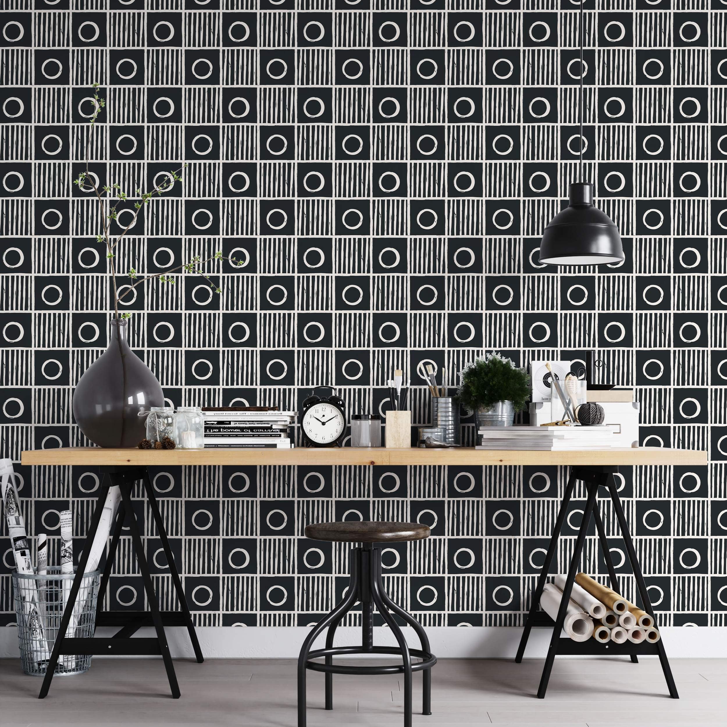 Geometric wallpaper with a grid of alternating black squares: one with a white circle, the other with vertical white stripes.