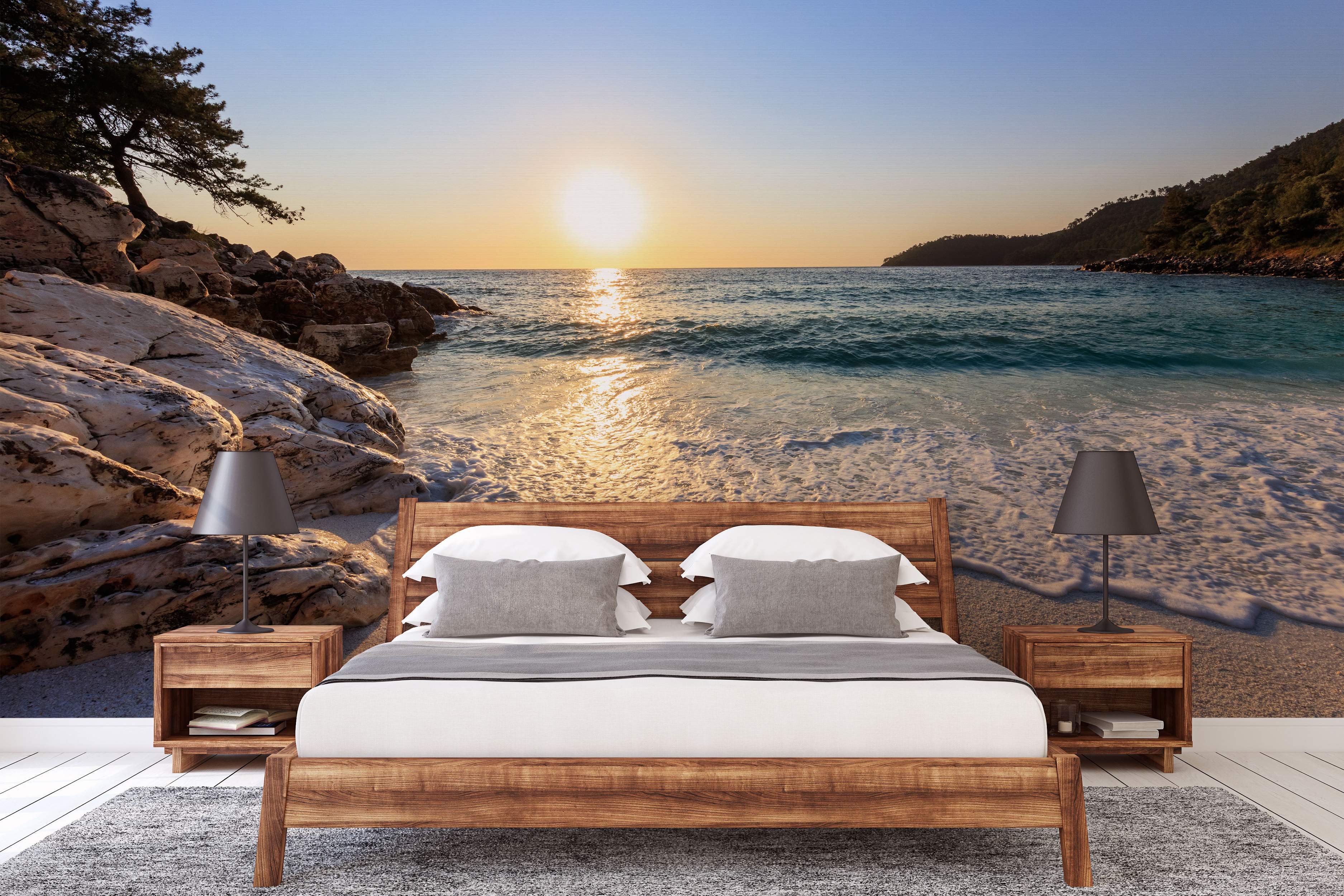 Scenic wall mural of a sunset over a beach cove, featuring calm blue water, sandy shore, and rocky coastline.