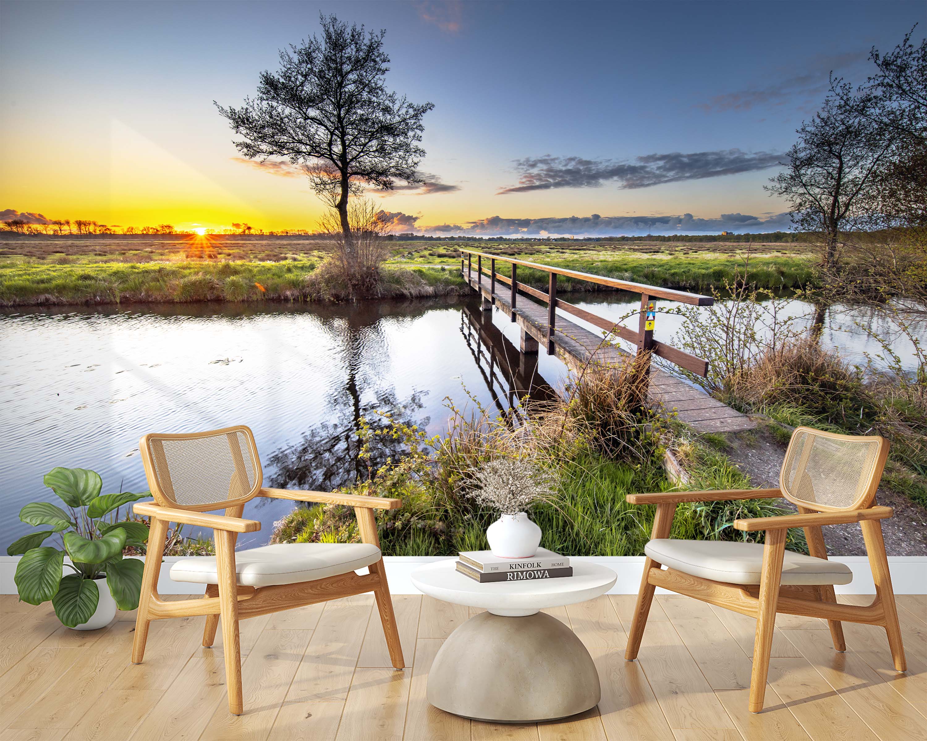 Mural of a scenic sunset over a marsh with a wooden footbridge crossing a tranquil river and a silhouetted tree.