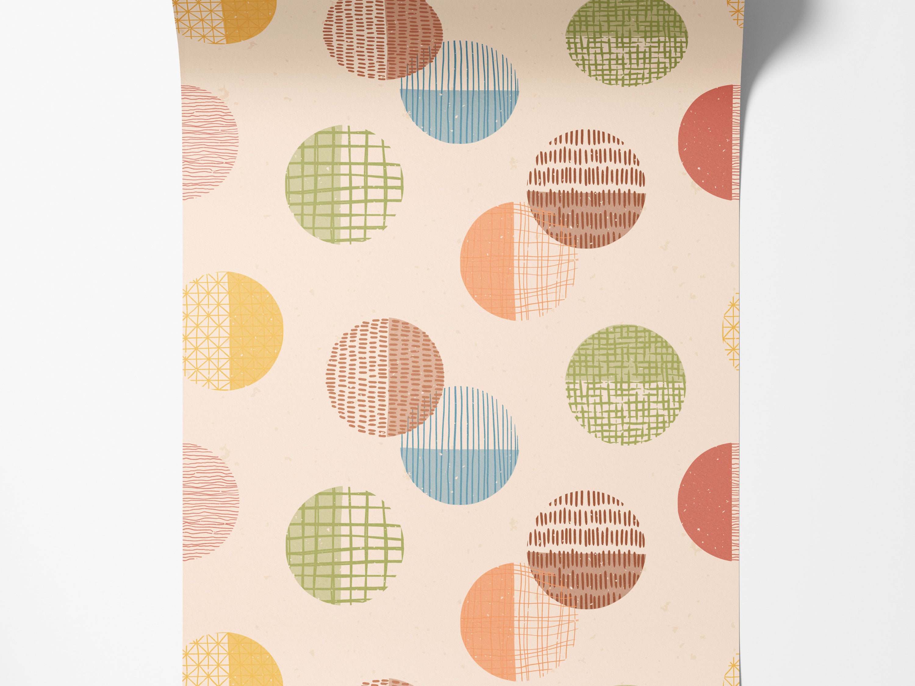 Wallpaper with a repeating pattern of textured circles in pastel yellow, orange, green, blue, and brown on a beige background.