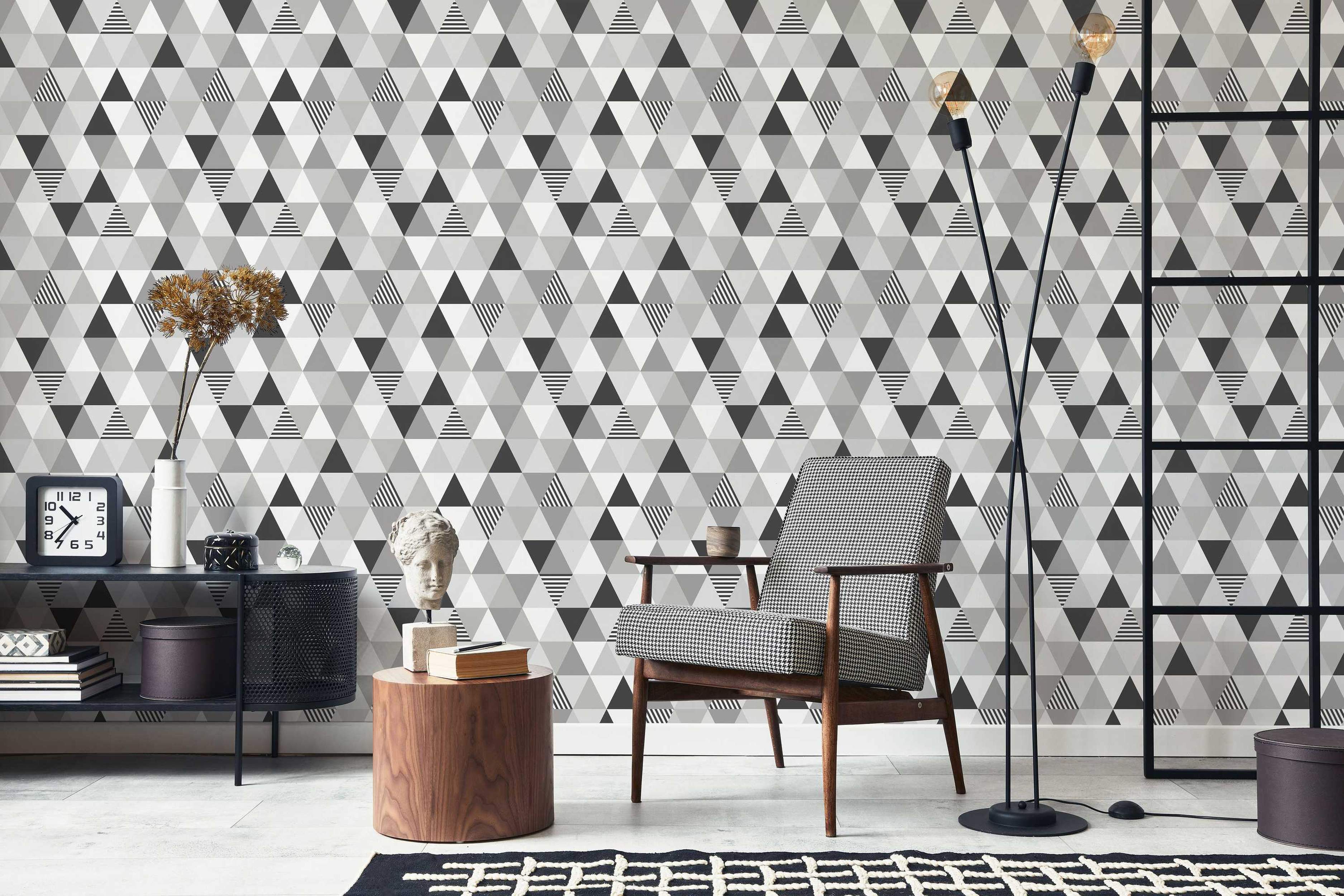 Geometric wallpaper with tessellating triangles in solid black, white, gray, and black and white horizontal stripes.