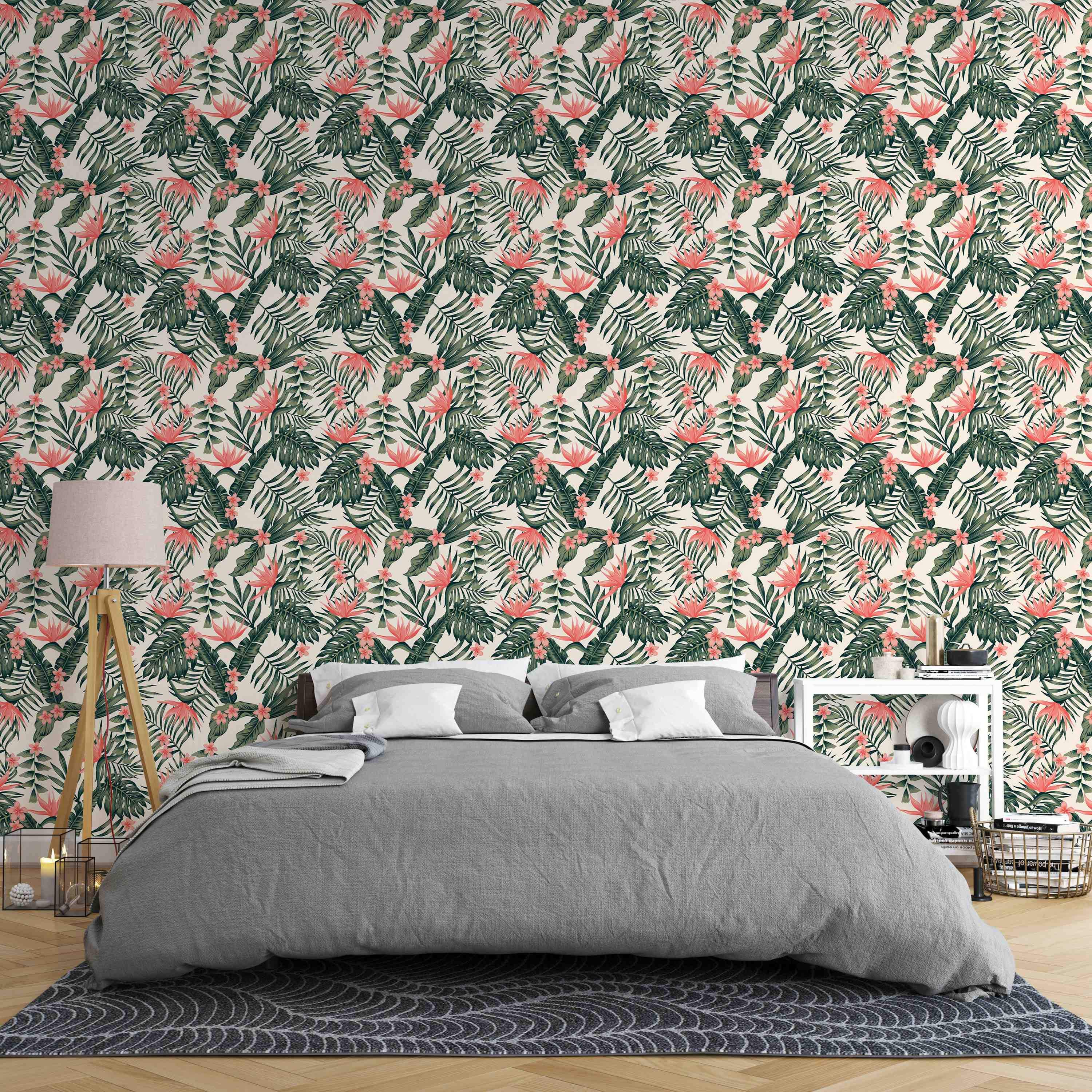 Tropical wallpaper with a dense pattern of green monstera and palm leaves, accented by coral bird of paradise and pink flowers.