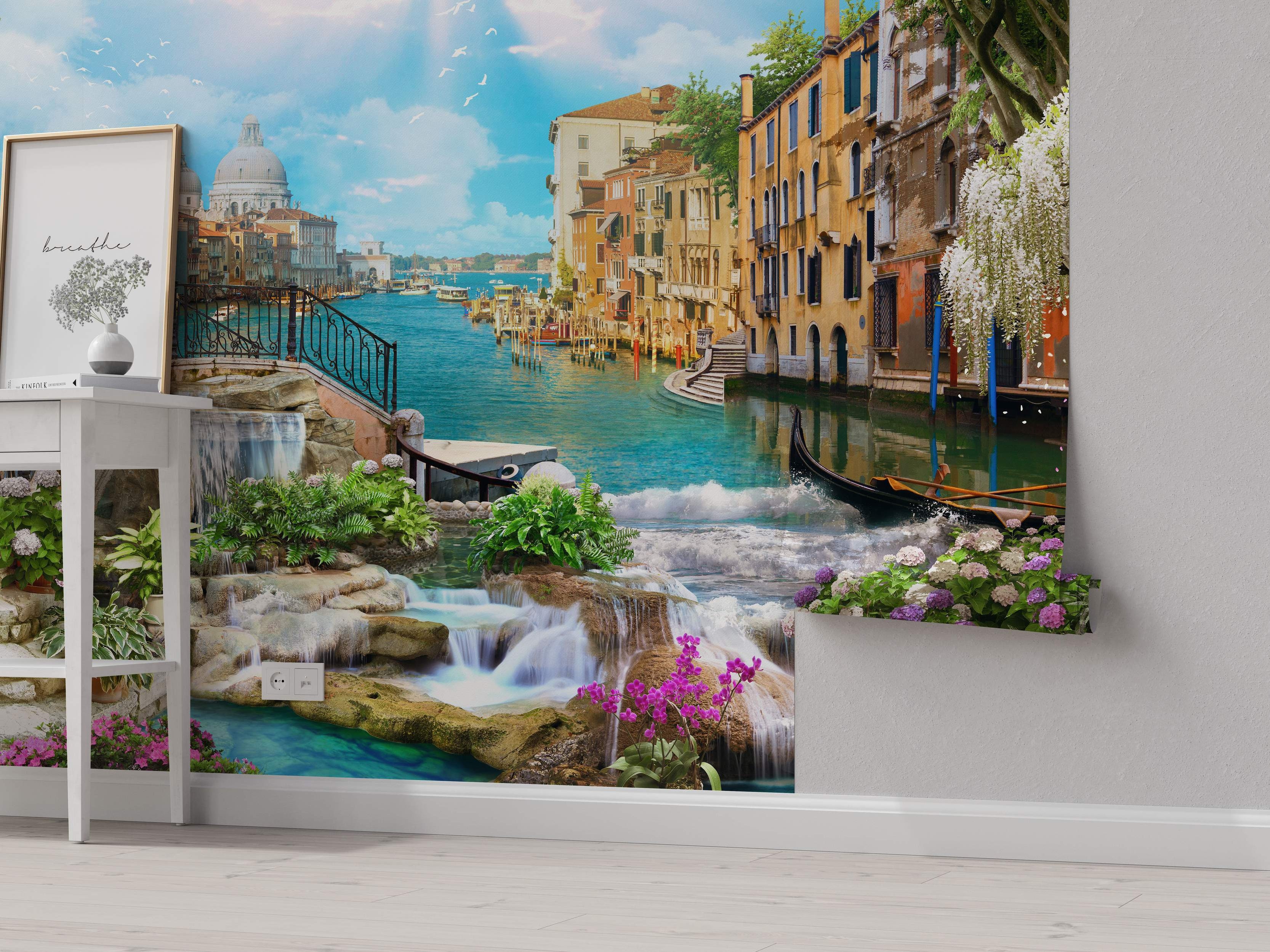 Photorealistic mural combining a Venice canal scene with blue water, colorful buildings under a blue sky, and foreground waterfalls with rocks and flowers.