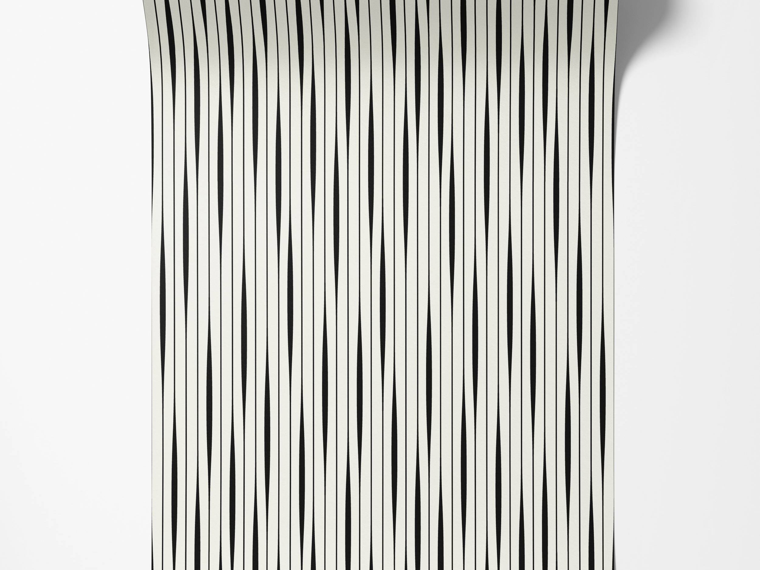 Wallpaper featuring vertical black stripes with a subtle taper on an off-white background.