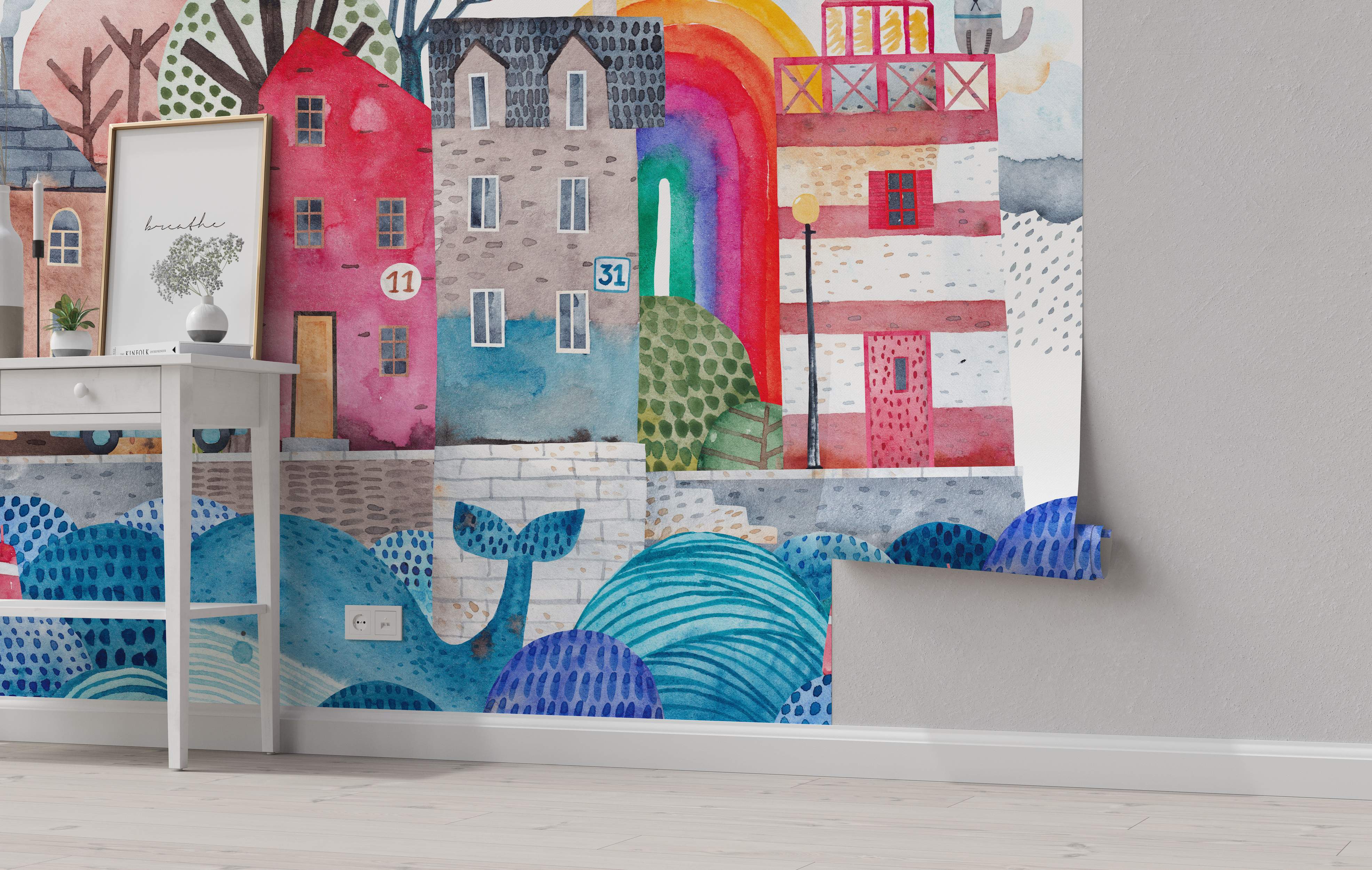 Watercolor mural depicting colorful stylized buildings, a rainbow, and large blue abstract waves with a whale tail at the bottom.