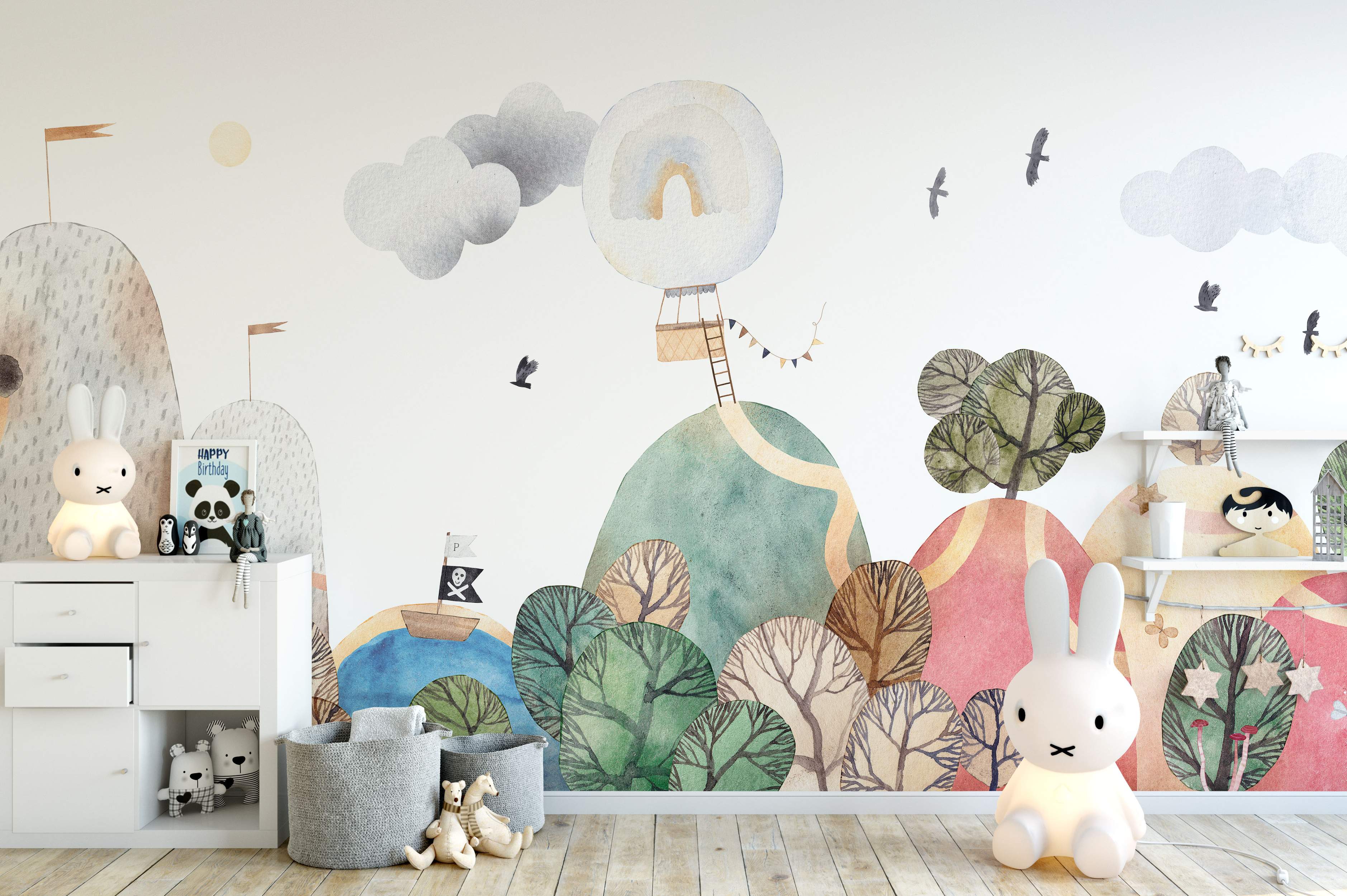 Whimsical watercolor landscape mural with soft green, pink, and gray hills, stylized trees, clouds, birds, and a hot air balloon.