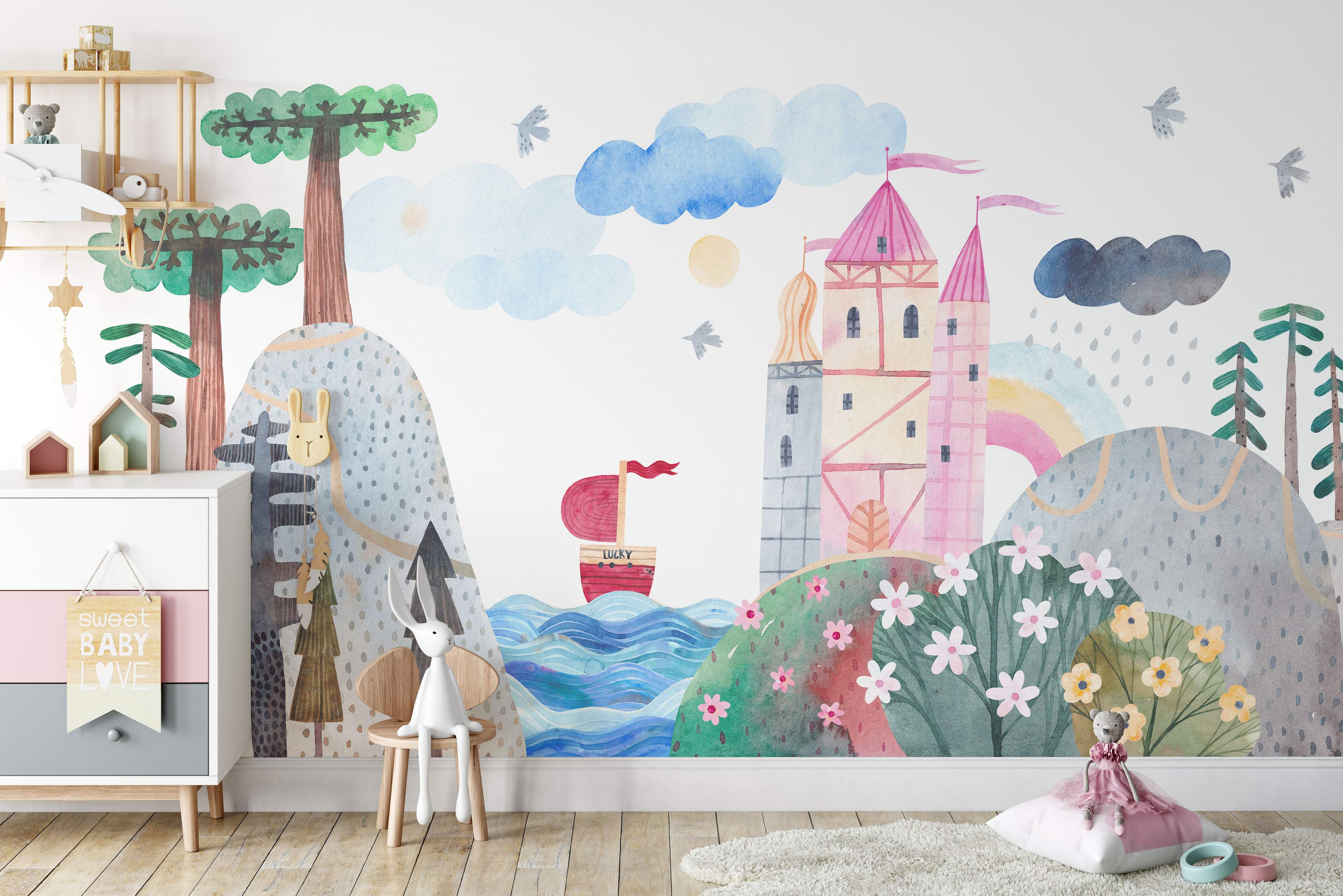Watercolor mural depicting a whimsical landscape with a pink castle, blue sea with a boat, green hills, trees, and clouds.