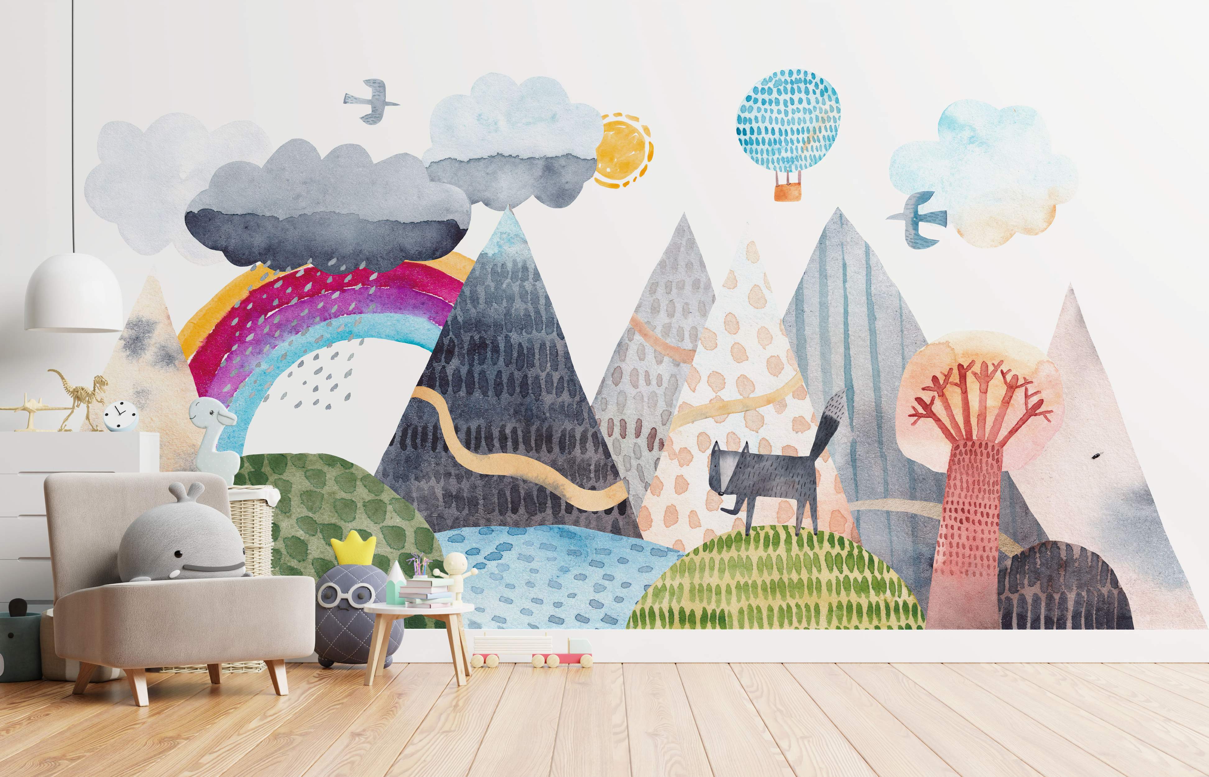 Whimsical watercolor landscape mural with patterned mountains, rolling hills, a bright rainbow, clouds, sun, hot air balloon, and a cat.