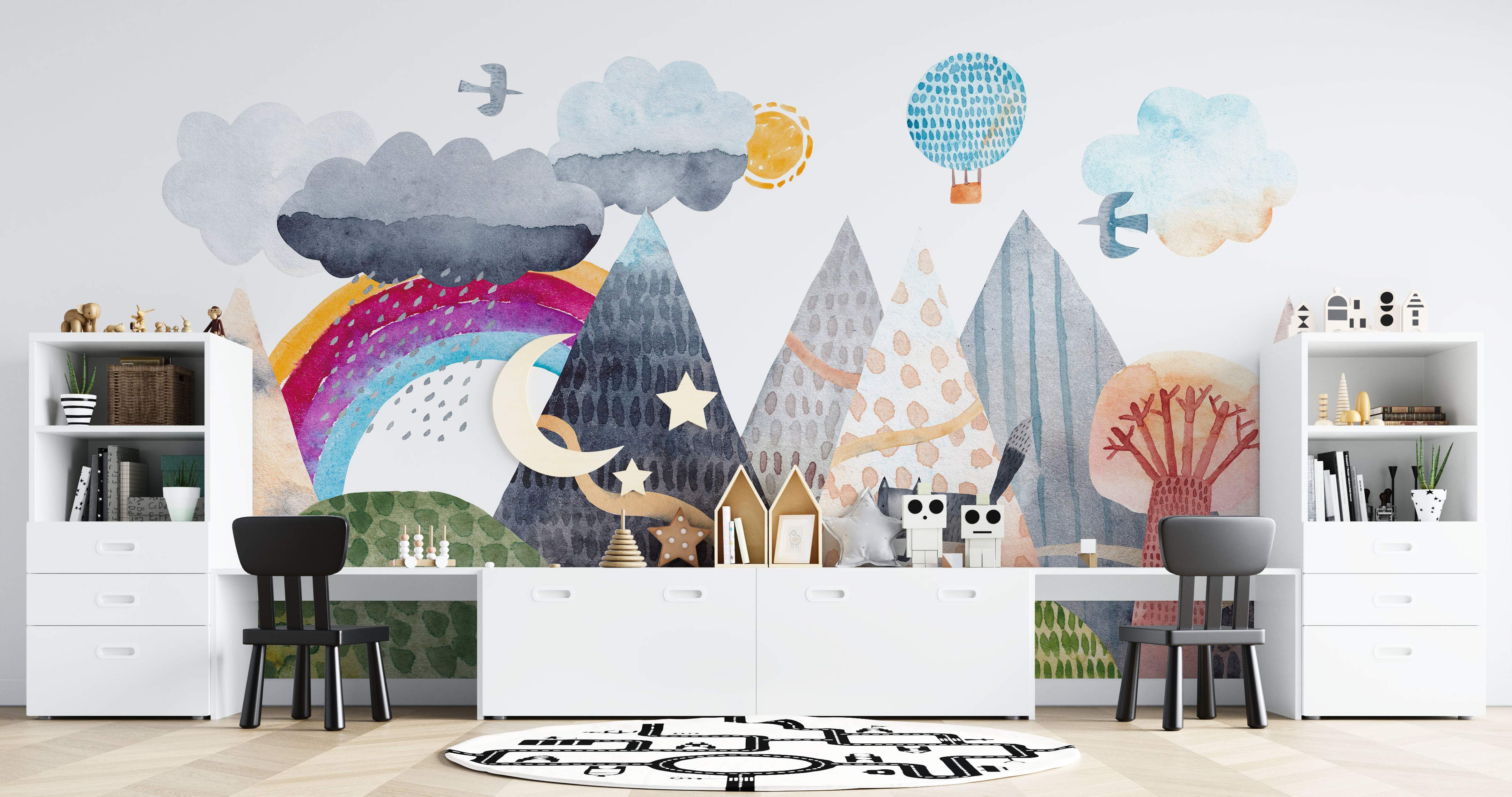 Whimsical watercolor mural with colorful mountains, clouds, rainbow, sun, moon, stars, birds, and a hot air balloon.