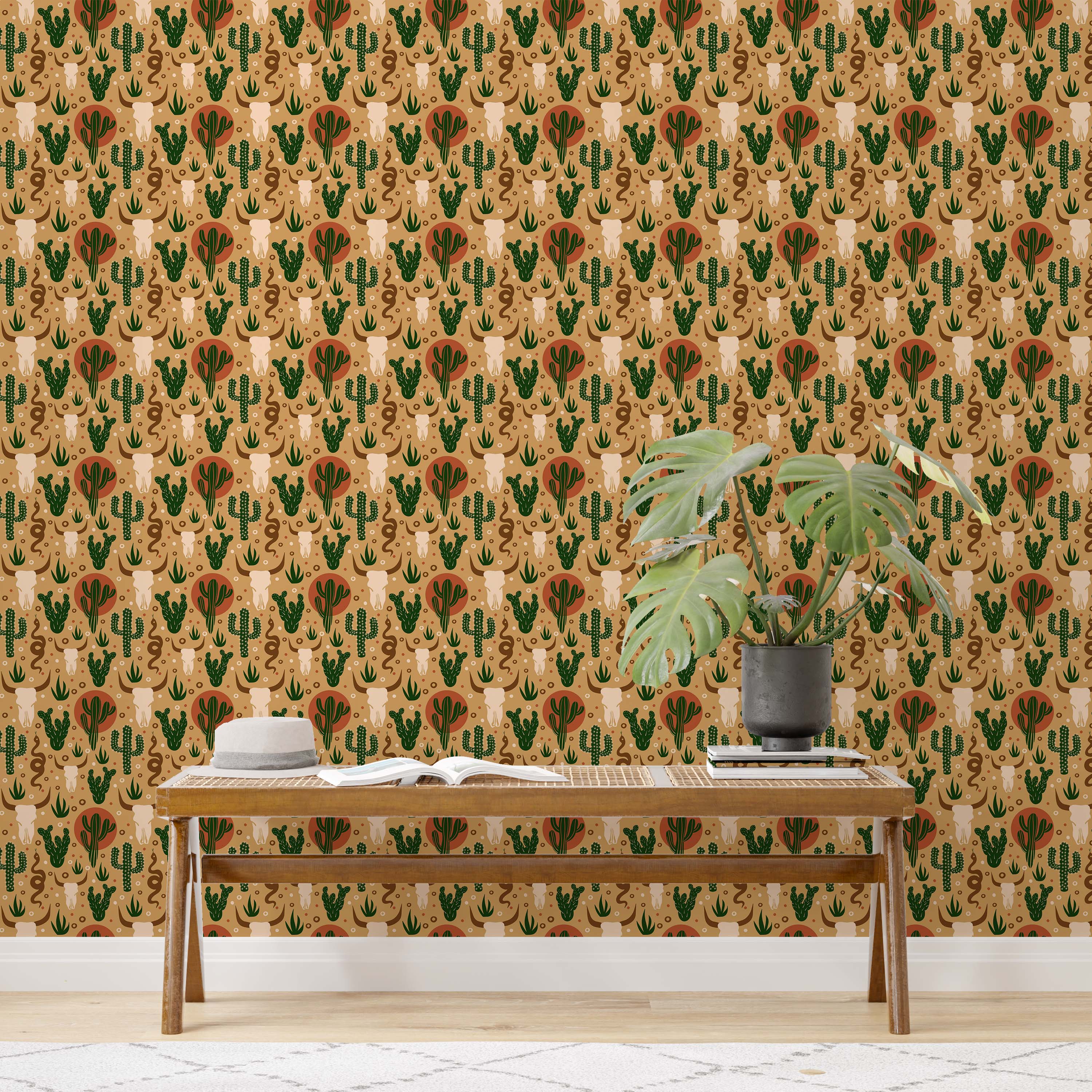 Southwestern wallpaper with illustrated cow skulls, green cacti, terracotta suns, and snakes on a tan background.