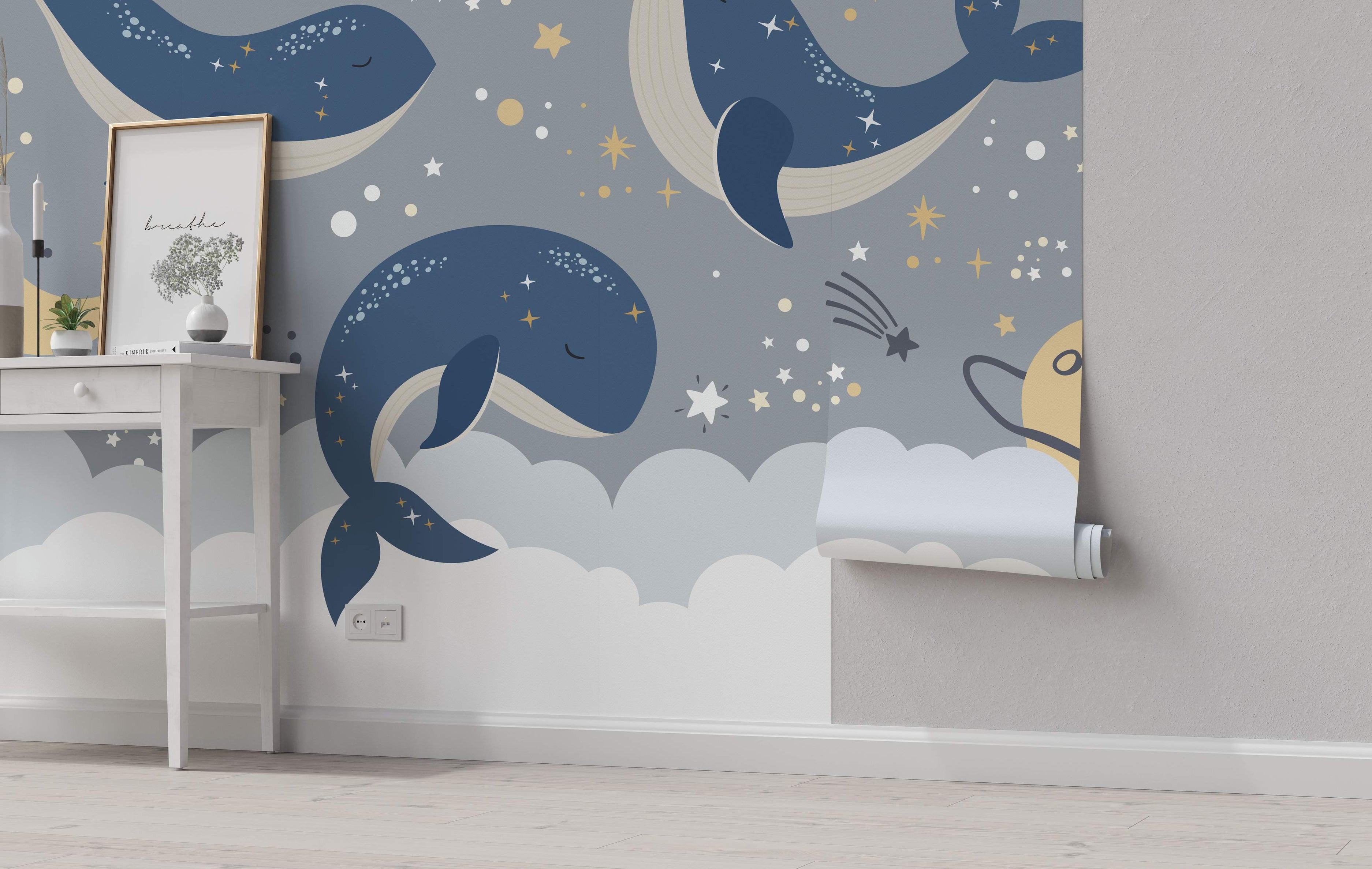 Celestial mural featuring cartoon blue whales floating among grey clouds, yellow and white stars, and a planet on a grey background.