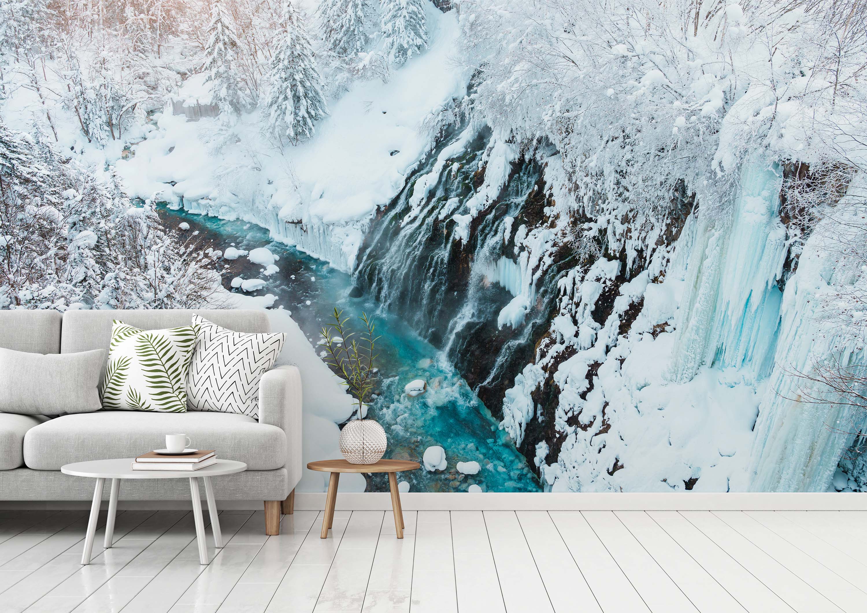 A wall mural of a partially frozen waterfall cascading into a vibrant turquoise river, surrounded by snow-covered trees and cliffs.